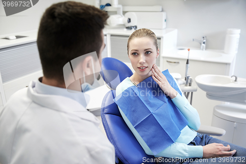 Image of male dentist with woman patient at clinic