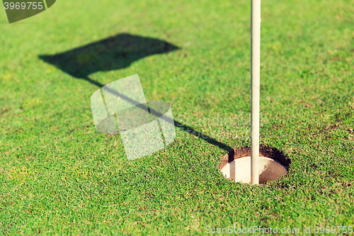 Image of close up of flag mark in hole on golf field