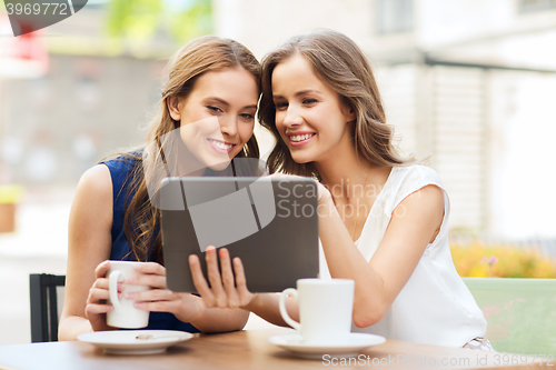 Image of young women with tablet pc and coffee at cafe