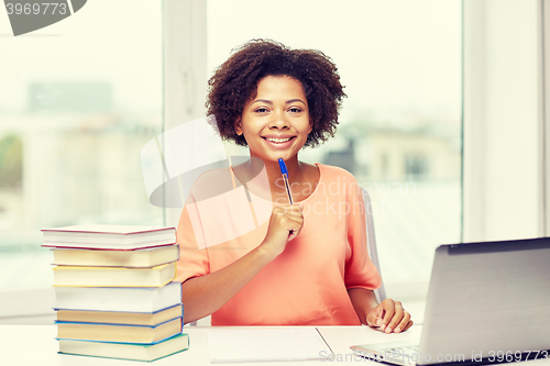 Image of happy african american woman with laptop at home