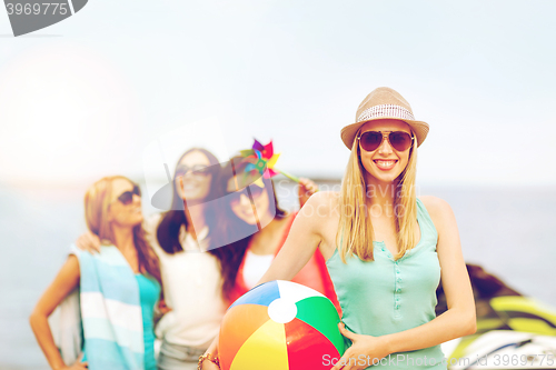 Image of girl with ball and friends on the beach