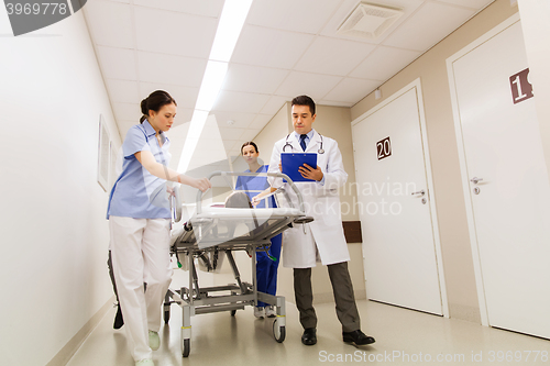 Image of medics with woman on hospital gurney at emergency