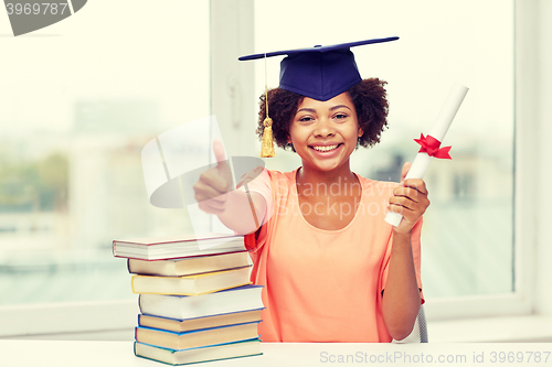 Image of happy african bachelor girl with books and diploma