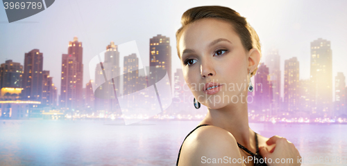 Image of beautiful young asian woman with earring in city 