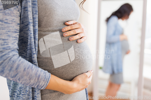 Image of close up of pregnant woman looking to mirror