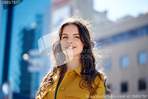 Image of happy smiling young woman on summer city street