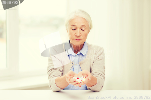 Image of senior woman with medicine at home