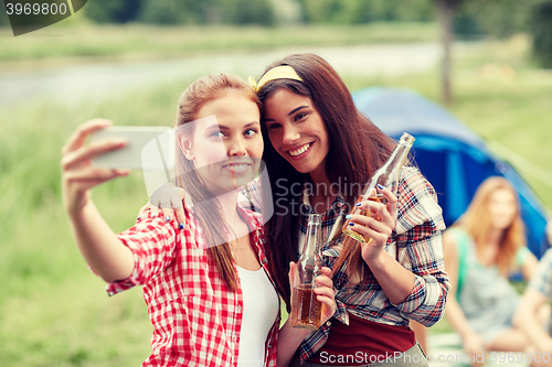 Image of happy women taking selfie by smartphone at camping