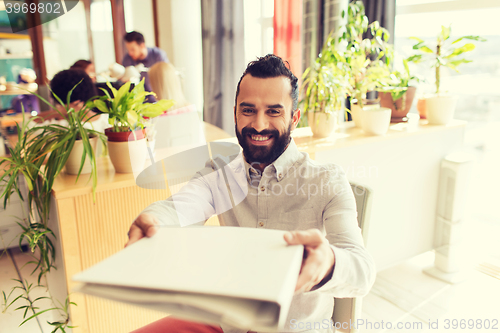 Image of happy creative male office worker with folfer