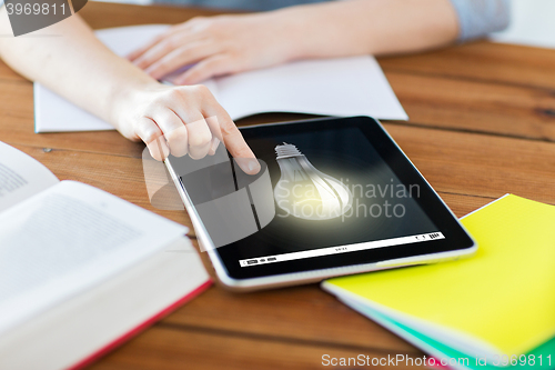 Image of close up of student with tablet pc and notebook