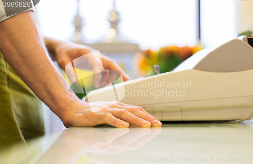 Image of close up of man or seller at flower shop cashbox