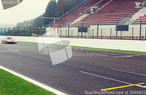 Image of close up of car driving on speedway track or road