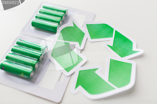 Image of close up of batteries and green recycling symbol