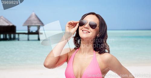 Image of happy woman in sunglasses and bikini on beach