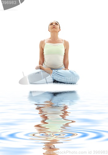 Image of padmasana lotus pose on white sand #2