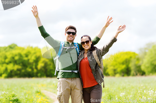 Image of happy couple with backpacks hiking outdoors