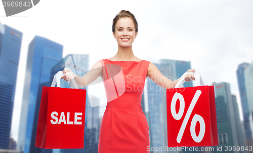 Image of happy woman with shopping bags over singapore city