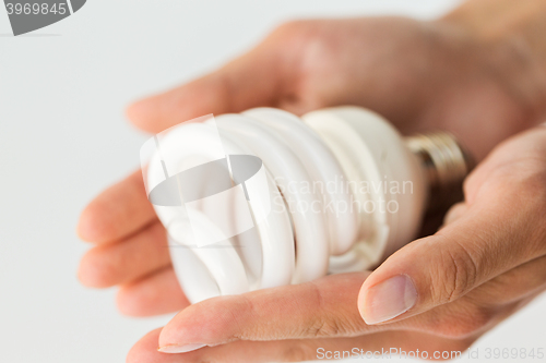 Image of close up of hands holding energy saving lightbulb