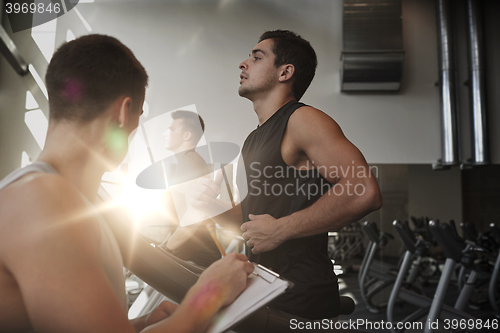 Image of men exercising on treadmill in gym