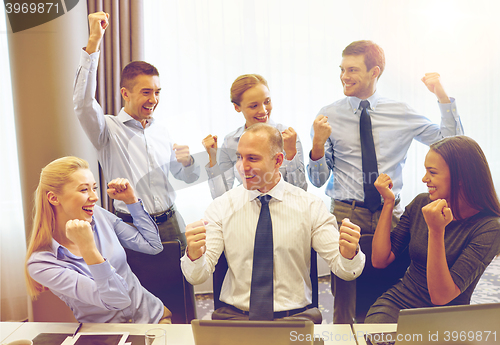 Image of business people celebrating victory in office