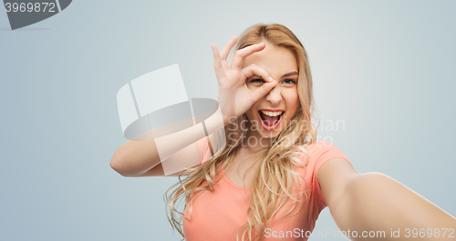 Image of happy smiling young woman taking selfie