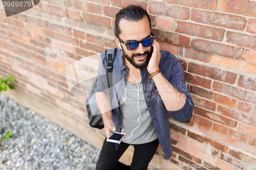 Image of happy man with earphones listening to music