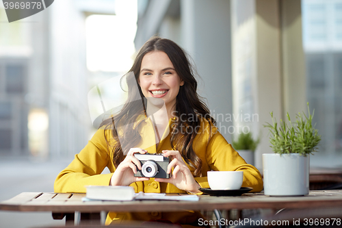 Image of happy tourist woman with camera at city cafe