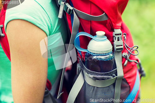 Image of close up of woman with water bottle in backpack