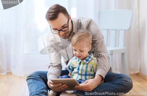 Image of father and son with tablet pc playing at home