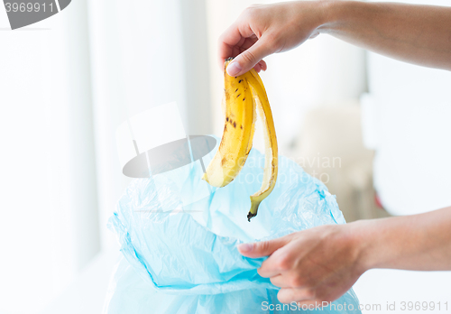 Image of close up of hand putting food waste to rubbish bag