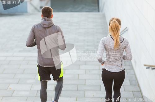 Image of couple running downstairs on city stairs