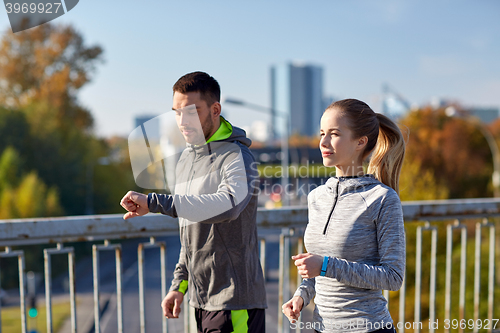 Image of couple running over city highway bridge