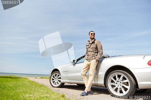 Image of happy man near cabriolet car outdoors