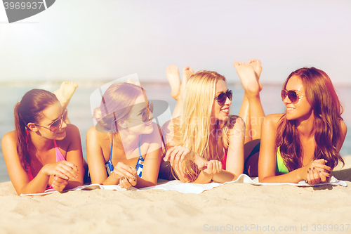 Image of group of smiling women in sunglasses on beach