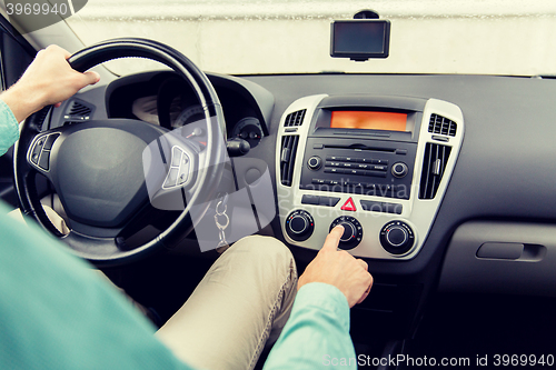 Image of close up of male hand using climate control in car