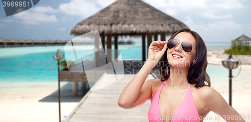 Image of happy woman in sunglasses and bikini on beach