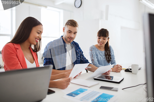 Image of happy creative team or students working at office