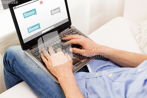 Image of close up of man typing on laptop computer at home