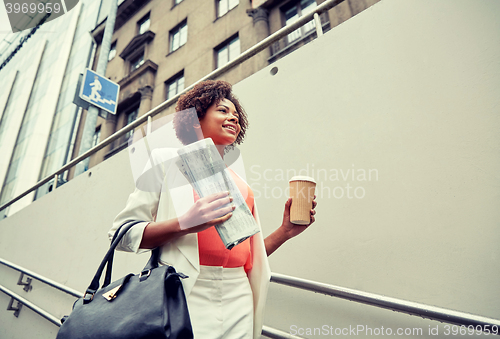 Image of happy african businesswoman with coffee in city