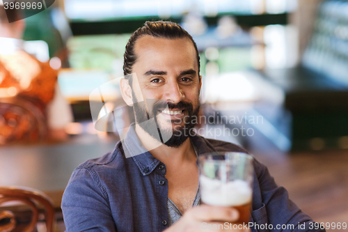 Image of happy man drinking beer at bar or pub