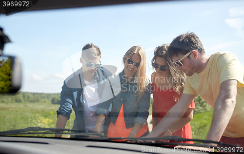 Image of happy friends with map and car searching location
