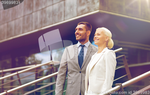 Image of smiling businessmen standing over office building