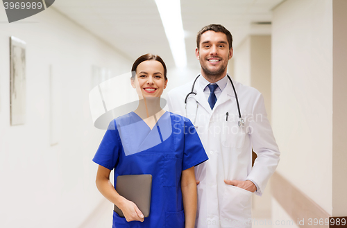 Image of smiling doctor in white coat and nurse at hospital