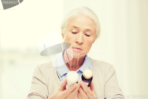 Image of senior woman with medicine jars at home