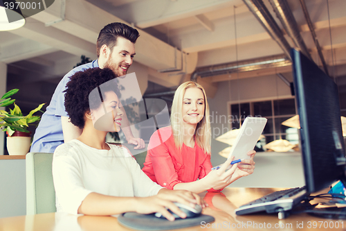 Image of happy creative team with computer in office