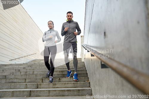 Image of happy couple running downstairs in city