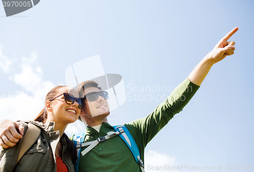 Image of happy couple with backpacks hiking outdoors
