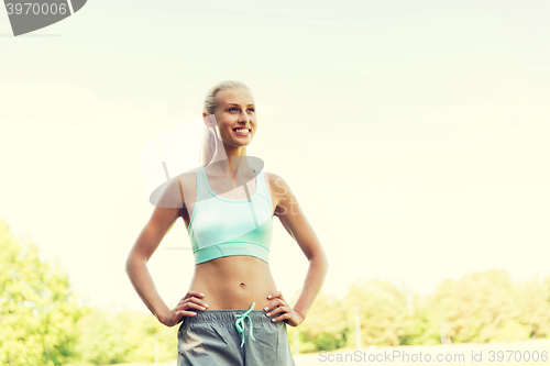 Image of happy young woman exercising outside