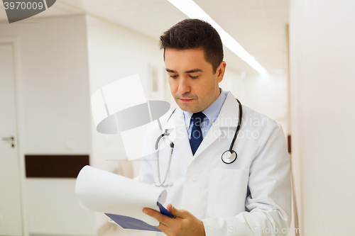 Image of doctor writing to clipboard at hospital