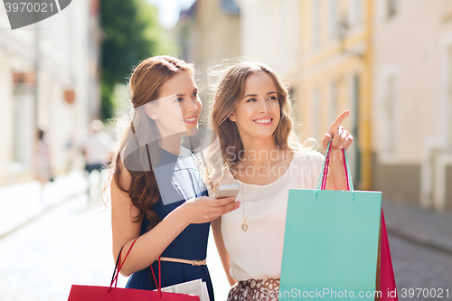 Image of happy women with shopping bags in city